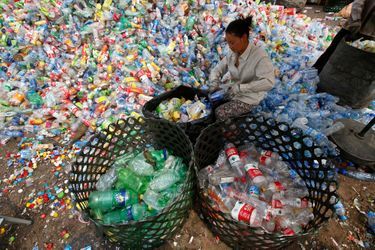 Une femme trie des déchets à Pékin (Chine). Le gouvernement estime que 4,67 millions de tonnes de déchets recyclables ont été collectés dans la ville en 2010.