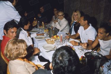 Brigitte Bardot, Romy Schneider, Alain Delon, Eric Tabarly, Maurice Roney et des amis dînent à Saint-Tropez, à la fin du mois d&#039;août 1968.
