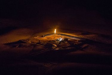 Vue d'un puit de gaz naturel qui procède à un torchage en pleine nuit, dans l'Etat du Dakota du Nord.