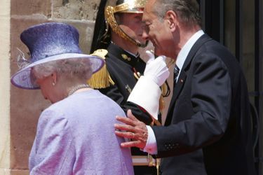 Jacques Chirac avec la reine Elizabeth II à Caen, lors des célébrations du 60e anniversaire du Débarquement en juin 2004. En touchant légèrement le dos de la reine, un geste interdit par le protocole, le président français avait scandalisé les tabloïds britanniques...