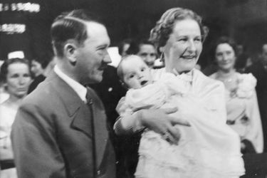 Edda Göring dans les bras de sa mère avec son parrain Adolf Hitler, en novembre 1938 lors de son baptême.