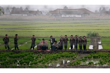 Un groupe de musiciens jouent au milieu des champs pour saluer les fermiers sur l&#039;île de Hwanggumpyong, près de la ville nord-coréenne de Sinuiju et de la ville chinoise de Dandong. 