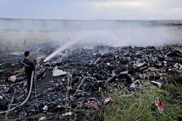 Grabovo, le 17 juillet. A quelques kilomètres de la frontière russe, les premiers sauveteurs arrivés sur les lieux du drame éteignent les flammes de l’incendie du Boeing 777. 
