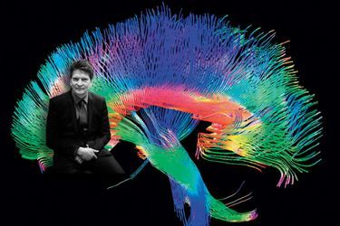 Henry Markram,  directeur du Human Brain Project, devant une image numérique d'un cerveau humain.
