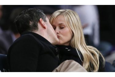 Reese Witherspoon embrasse son époux Jim Toth lors d’un match de basketball entre les Toronto Raptors et les Los Angeles Lakers. 