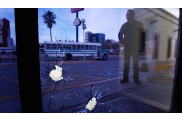 Une personne se trouve devant une vitre criblée de trous au journal El Diario dans la ville de Juarez au Mexique. Le principal journal de la vile et une télévision locale ont été la cible de coups de feu. Aucun blessé n’est pas à déplorer. Plusieurs hommes dans une voiture ont été aperçus en train de viser les locaux des rédactions.