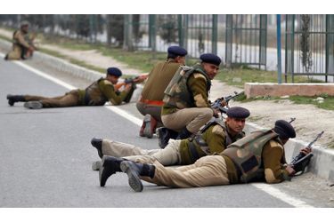 Des policiers indiens se mettent à couvert à Srinagar, où deux terroristes se sont retranchés mercredi dans un camp paramilitaire de la partie indienne du Cachemire.