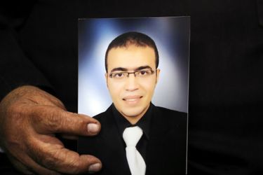 Reda al-Hamahmy, le père du suspect de l'attaque au Carrousel du Louvre, tenant une photo de son fils.