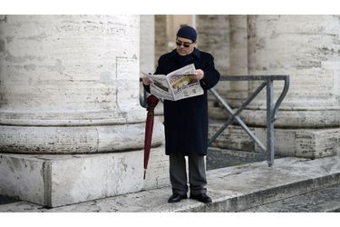 Un homme lit le journal au lendemain de l’élection du nouveau pape, François. 