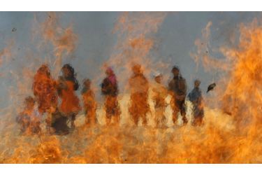 Des enfants afghans regardent des articles médicaux et de la nourriture périmée, brûler dans un feu allumé à la périphérie de Jalalabad. 