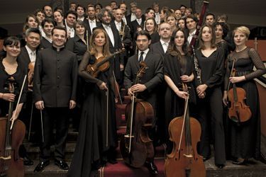 Anne Gravoin, entre Lionel Bringuier (à g.) et le violoncelliste Gautier Capuçon, soliste invité, devant les 48 musiciens de l'Alma Chamber Orchestra. 