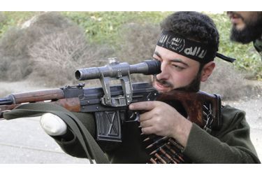 Dans la campagne entourant Alep, en Syrie, un combattant de l'Armée syrienne libre, amputé du bras, vise des loyalistes avec son fusil.