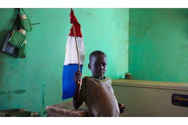 Un jeune garçon tient un drapeau français artisanal dans la ville récemment libérée de Douentza, au Mali.