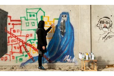 L'artiste afghane Malina Suliman peint sur un mur de Kandahar.