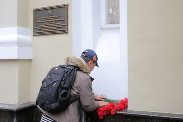 Un homme dépose des fleurs devant l&#039;immeuble qui accueille les choeurs de l&#039;Armée Rouge. 