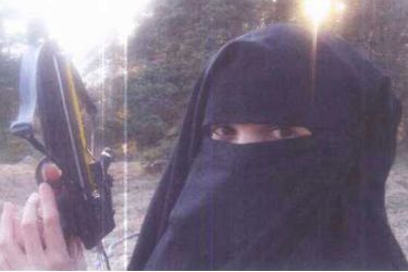 Hayat Boumeddiene jeune femme portant le niqab, tenant une arbalète lors d'une séance de tir. Des photographies prises par le couple, en 2010, au cours d'un séjour dans le Cantal, chez Djamel Beghal, alors assigné à résidence à Murat. 