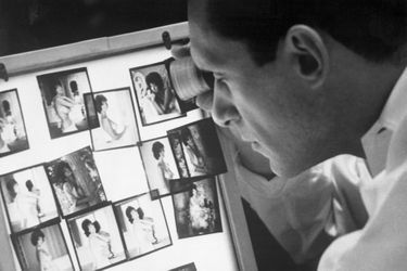 Au travail, Hugh Hefner analyse les photos prises pour son magazine. 