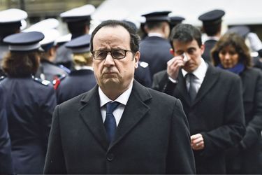 Mardi 13 janvier, dans la cour de la préfecture de police de Paris. Derrière François Hollande, Manuel Valls, bouleversé.