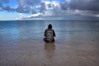 Une femme contemple son mari qui pèche au large des îles Kiribati (Pacifique central). Des atolls dangereusement menacés par la montée des eaux liée au réchauffement planétaire.