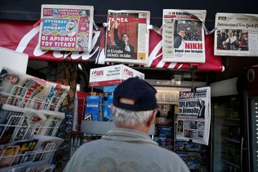 Un homme regarde les Unes des journaux grecs aux lendemains d&#039;une élection historique.