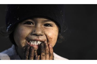 Une petite fille sourit pendant que ses parents récoltent du café dans une plantation de San Isidro, au nord-est de San Jose, au Costa Rica. 