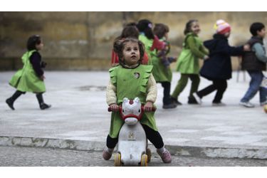 Une petite écolière arrête de jouer et regarde vers le ciel alors qu’elle vient d’entendre le bruit d’un bombardement à Al-Tawheed, en Syrie. 