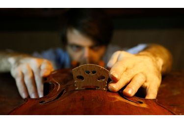Le luthier français Mathias Menanteau répare ​​un violon dans son atelier dans le centre de Rome.