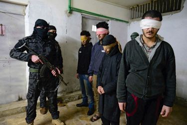 Dans le sous-sol d’un ex-commissariat de Til Koçer, lundi 15 décembre, quatre islamistes surveillés par des Kurdes qui restent masqués, pour éviter d’être identifiés par Daech.