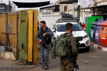 Un policier et un soldat israéliens patrouillent à Barkan, où a eu lieu l'attaque, le 7 octobre 2018.