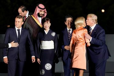 Le président des Etats-Unis Donald Trump embrasse Brigitte Macron lors du diner officiel du G20 à Osaka.