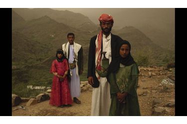 Devant les montagnes du Yémen d’où elles sont originaires, Tahani (robe rouge) pose avec sa belle-sœur Gada et leurs maris, des militaires. Tahani a été mariée à 6 ans avec un homme de 25 ans. « Au début, quand je le voyais, je me cachais. Je le haïssais. »