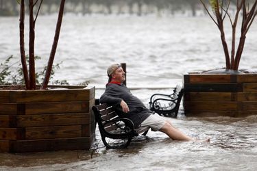 A Wilmington, un homme, résigné, se repose, les pieds dans l'eau alors que la Cape Fear River a inversé son cours...