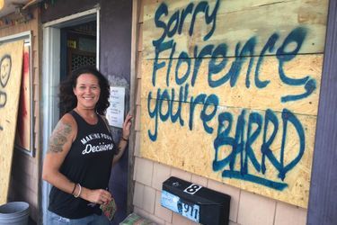 Lisa Lowery devant le Pelican Bar, une institution a Carolina Beach, qui a barricadé ses vitrines «Désolé Florence, tu n’es pas là bienvenue», dit le tag sur la plaque de bois qui protège la vitrine. 