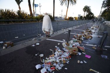 Un homme marche à coté des débris abandonnés dans la panique après l&#039;attaque sur la promenade des Anglais à Nice. 