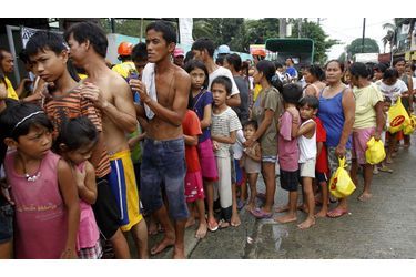 Les victimes des inondations font la queue pour obtenir de la nourriture.