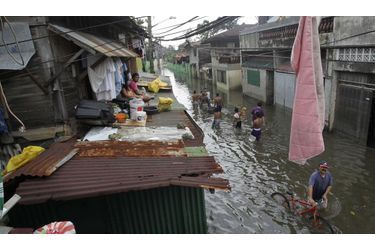Pour éviter d'être embourbé par la montée des eaux boueuses, les habitants de la capitale des Philippines gagnent de la hauteur en se réfugiant sur les toits de la ville.