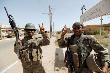 Deux soldats célèbrent leur victoire dans le centre de Fallouja, le 17 juin 2016.