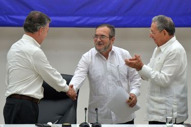 Sous le regard de Raul Castro (à droite), le président colombien Santos serre la main de Timoleon Jimenez, alias &quot;Timochenko&quot;, le chef des Farc