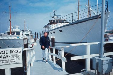 John Wayne à côté de son yacht de quarante cinq mètres, "The Wild Goose" (l'Oie sauvage), un ancien dragueur de mines, à Newport Beach, Californie, en juin 1967.