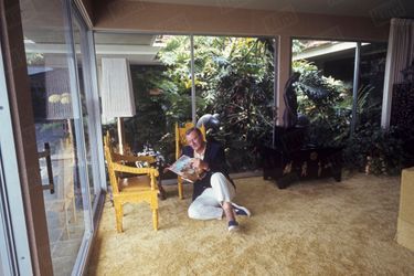 John Wayne lisant Paris Match, dans son salon, à Newport Beach, Californie, en juin 1967.