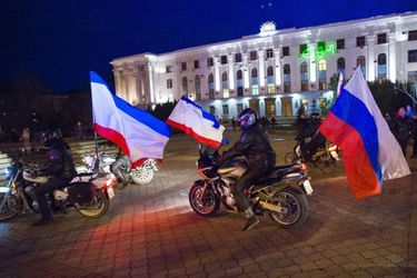 Sur la place Lénine de Simferopol, la capitale de la Crimée, des motards brandissent le drapeau russe, dimanche.