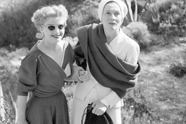 Festival de Cannes, 1953 : l'actrice américaine Anne Baxter et Arletty posant au bord d'une route.