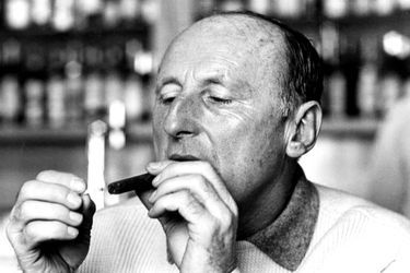 Suisse, Montana, 1966 : Bourvil au restaurant lors de vacances de neige, en train de s&#039;allumer un cigare.