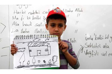 Ali Hicaz, 10, un réfugié syrien, montre un dessin de sa maison de rêve au cours d&#039;une classe au camp de réfugiés de la province de Hatay Boynuyogun près de la frontière turco-syrienne (avril 2012).