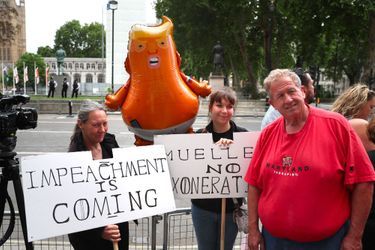«La destitution approche», proclame la pancarte de gauche. Un ballon Trump, symbole de ralliement des anti-Trump britanniques, est également présent.