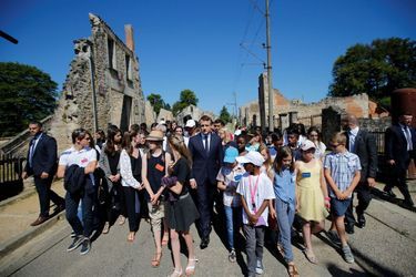 Le président de la République visite avec des enfants les ruines du village martyr. 