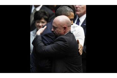 Barack Obama s'est rendu mercredi au chevet de Gabrielle Giffords, l'élue grièvement blessée à la tête lors d'une fusillade, à l'entame d'un déplacement chargé d'émotion en Arizona. Peu après son atterrissage à Tucson, le président américain s'est immédiatement rendu à l'hôpital universitaire où est soignée la démocrate de 40 ans, prise pour cible lors d'une rencontre avec des électeurs samedi sur un parking. Il a ensuite prononcé un discours lors d'une cérémonie en hommage aux six personnes tuées et aux 14 autres blessées par Jared Lee Loughner, un jeune homme de 22 ans. "Aucun de nous ne peut savoir exactement ce qui a déclenché cette attaque brutale. Aucun de nous ne peut savoir avec certitude ce qui aurait pu empêcher ces coups de feu d'être tirés ni quelles pensées se cachaient dans les tréfonds du cerveau de cet homme violent", a-t-il déclaré. Sur la photo, il serre dans ses bras Mark Kelly, le mari de Gabrielle Giffords.