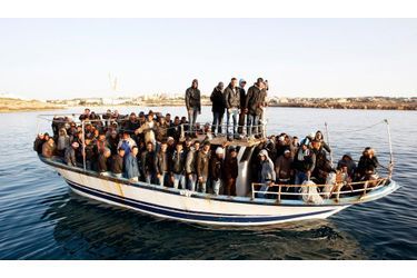  Un bateau de migrants originaires du Maghreb arrive près des côtes de l’île italienne de Lampedusa, fuyant les régimes en place et les révolutions en cours.