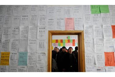 Du pain sur la planche. En Chine, des employés migrants cherchent des informations sur leur futurs emplois. 