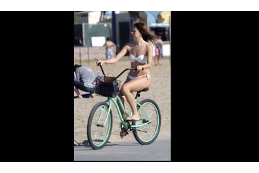 Une jeune femme fait du vélo sur la plage de Santa Monica alors que la température flirte avec les 30 degrés à Los Angeles, un record en cette saison.